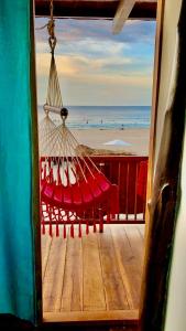 a hammock on a deck with a view of the beach at Cabaña The Sunset in Santa Marta
