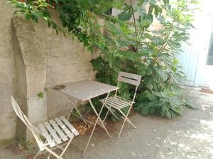 アジャンにあるStudio Centre Ville Sacre Coeurの壁に座るテーブルと椅子2脚