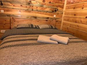 a bed in a log cabin with two pillows on it at Alpine House in Žabljak