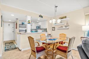 ein Esszimmer und eine Küche mit einem Tisch und Stühlen in der Unterkunft Unit 5211 - Ocean Racquet Resort in Saint Augustine Beach