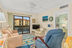 sala de estar con sofá, sillas y TV en Unit 5211 - Ocean Racquet Resort, en St. Augustine Beach