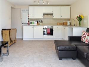 a living room with a couch and a kitchen at Old Church School in Plympton