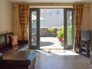 a living room with a couch and a sliding glass door at Old Church School in Plympton