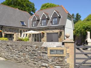 a stone house with a sign in front of it at Old Church School in Plympton