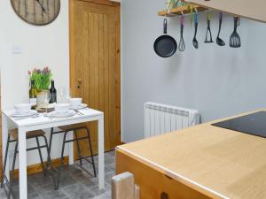 a kitchen with a white table and a white counter top at Shoemakers Steading in Hopeman