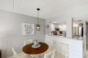a dining room with a wooden table and white chairs at 3118 Near Ocean 1st Floor SE in Saint Augustine Beach