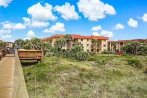 eine Bank auf einer Promenade vor einem Gebäude in der Unterkunft 3118 Near Ocean 1st Floor SE in Saint Augustine Beach