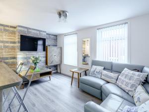 a living room with a couch and a tv at Kays in Cleveleys