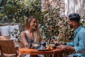 Ein Mann und eine Frau sitzen an einem Tisch in der Unterkunft Oriundo Luxury Nature Villas in Valladolid