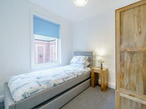 een kleine slaapkamer met een bed en een raam bij Kays in Cleveleys