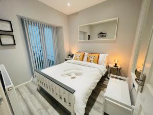 a small bedroom with a bed and a large window at Bristol City Stays - Harbourside Apartments in Bristol