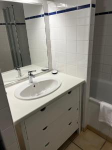 La salle de bains est pourvue d'un lavabo, d'un miroir et d'une baignoire. dans l'établissement 11 Les Pins Penchés, à Neufchâtel-Hardelot