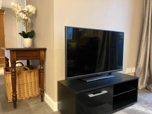 a flat screen tv sitting on top of a black entertainment center at Buckingham Court in St. Albans