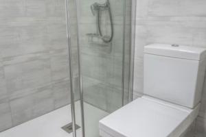 ein Bad mit Dusche, WC und Glasdusche in der Unterkunft Brisa Marinera Grupo AC Gestion in Cádiz