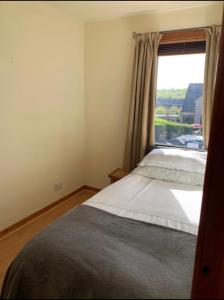 um quarto com uma cama e uma janela em Stornoway Holiday Let em Stornoway