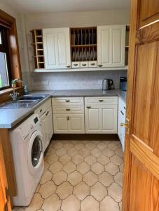 a kitchen with a washing machine and a sink at Stornoway Holiday Let in Stornoway