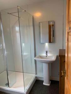 a bathroom with a glass shower and a sink at Stornoway Holiday Let in Stornoway