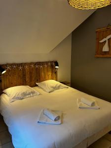 a bedroom with a bed with two towels on it at 11 Les Pins Penchés in Neufchâtel-Hardelot