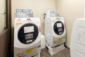 two washing machines sitting next to each other in a room at HOTEL VISCHIO TOYAMA in Toyama