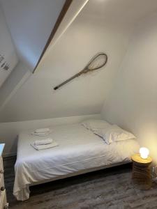 a bedroom with a bed with a racket on the wall at 11 Les Pins Penchés in Neufchâtel-Hardelot