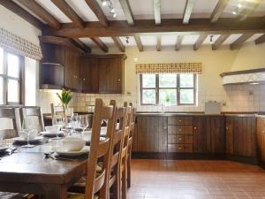 una cocina con una mesa de madera con sillas y un asterisco en Green Lane Cottage, en Newtown