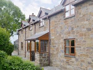 an external view of a stone house with awning at Green Lane Cottage in Newtown