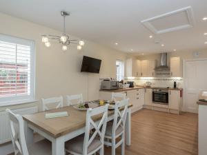 a kitchen and dining room with a table and chairs at The Coach House in Wootton Bridge