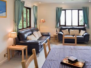 a living room with a leather couch and a table at Rivendell - Ukc2323 in St Ives