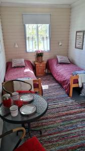Habitación con 2 camas y mesa. en Savikulma B&B en Mynämäki