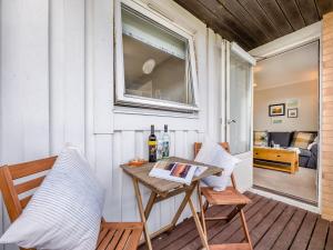 a table and chairs on a porch with a window at Dunes Court in Beadnell