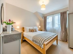 a bedroom with a bed and a large window at Dunes Court in Beadnell