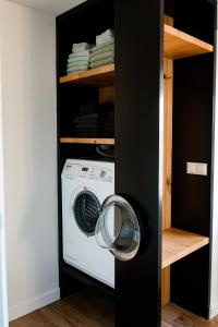a laundry room with a washing machine in a black closet at Landelijk gelegen vakantiewoning in Oldebroek