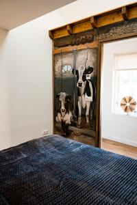 ein Schlafzimmer mit einem Wandbild von Kühen in der Unterkunft Landelijk gelegen vakantiewoning in Oldebroek