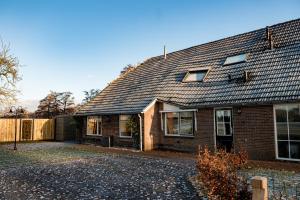 una casa de ladrillo con techo negro en Landelijk gelegen vakantiewoning, en Oldebroek