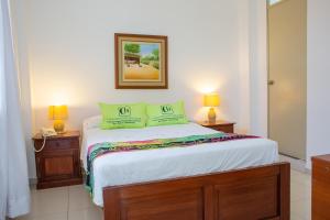 Hotel Country Boutique في بيورا: غرفة نوم مع سرير مع مواقف ليلتين ومصباحين