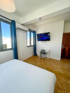 a bedroom with a white bed and a tv at Urbana Hotel in San Juan