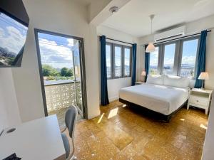Urbana Hotel في سان خوان: غرفة فندقية بسرير ونوافذ كبيرة