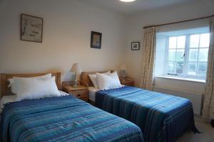 切爾滕納姆的住宿－The Snicket - Traditional Cotswold Home，一间卧室设有两张床和窗户。