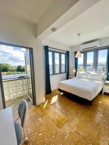 1 dormitorio con 1 cama grande y balcón en Urbana Hotel, en San Juan