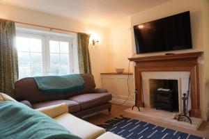 a living room with a couch and a fireplace at The Snicket - Traditional Cotswold Home in Cheltenham