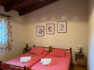 two beds in a bedroom with red sheets and towels at Mas del Carrascal in Chodos +55 photos