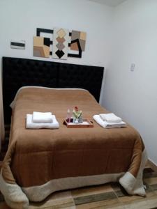 a bed with two towels and a doll on a tray at Complejo San Antonio in Fiambala