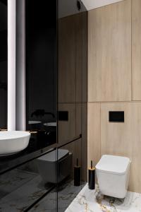 une salle de bain avec des toilettes blanches et un lavabo dans l'établissement Republiki Korczakowskiej Apartamenty, à Cracovie