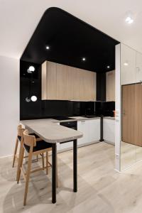 a kitchen with a table and chairs and a black ceiling at Republiki Korczakowskiej Apartamenty in Kraków