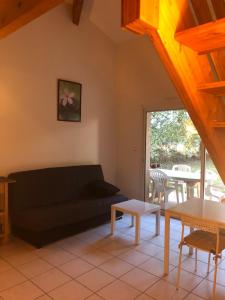 a living room with a couch and a table at Meublés de Margastau in Dieupentale