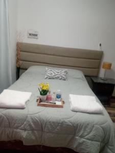 a bed with a tray with flowers and candles on it at Complejo San Antonio in Fiambala