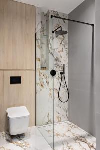 a bathroom with a shower and a toilet at Republiki Korczakowskiej Apartamenty in Kraków