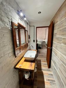 ein Bad mit einem Waschbecken an der Wand in der Unterkunft LA POSADA in Aiguá