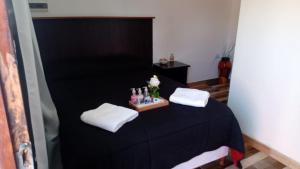 a room with a black bed with white towels and bottles at Complejo San Antonio in Fiambalá