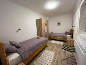 a small bedroom with two beds and a mirror at ALFA Apartmani in Subotica